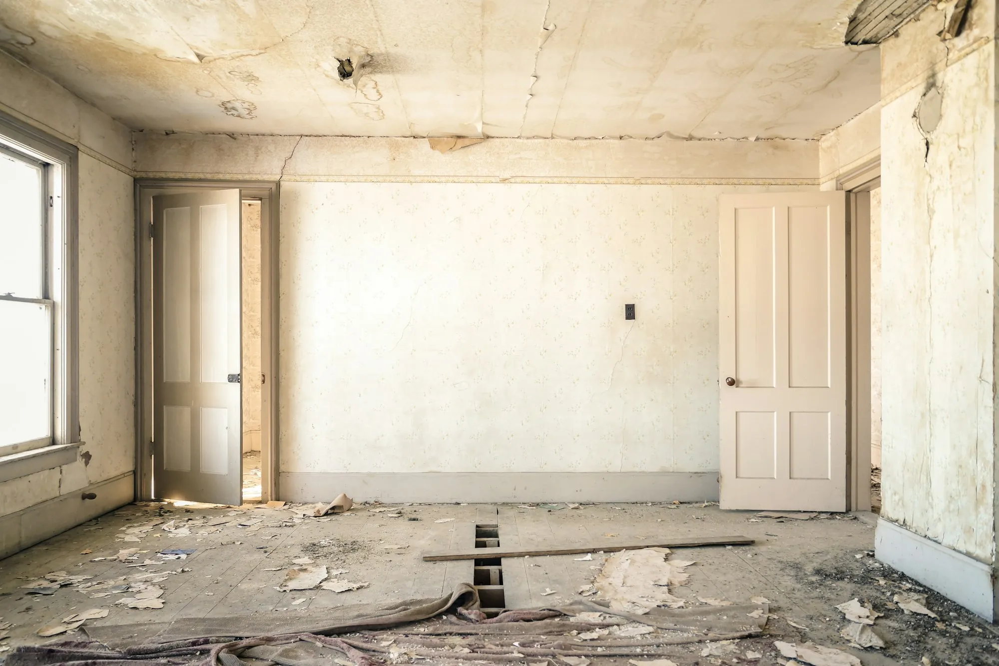 Bare room cleared out with debris on the floor